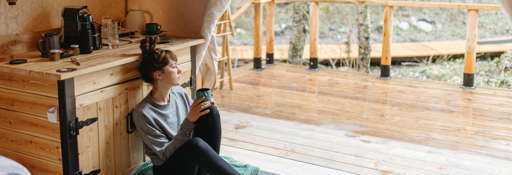 image shows women in glamping tent with a hot drink