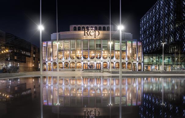 Photo by Kris Askey - A wide shot of exterior of The Rep Theatre within Centenary Square. A reflection of the building can be seen the water from the