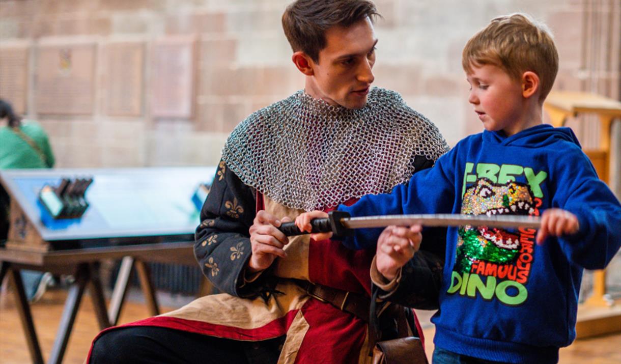 Knight teaching a child some sword techniques