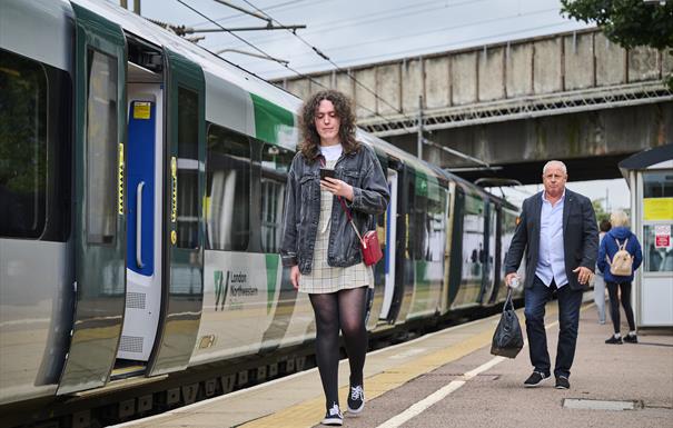 People walking by the train on the platform