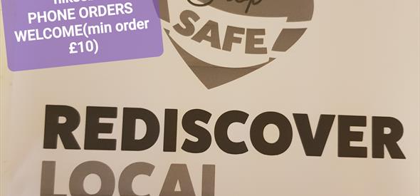 Purple sticker with shop information over a brown poster with shop safe, rediscover local logo.