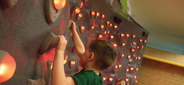 Kid on illuminated climbing wall