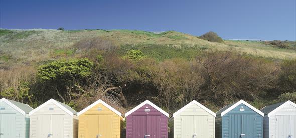 Colourful array of beach huts under the overcliff