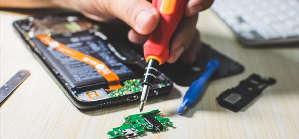 Someone repairing a phone with screwdriver