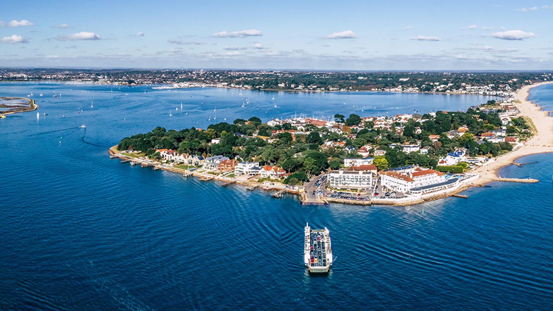 Aerial shot of Sandbanks in Poole on a beautiful sunny day with the ferry arriving to dock