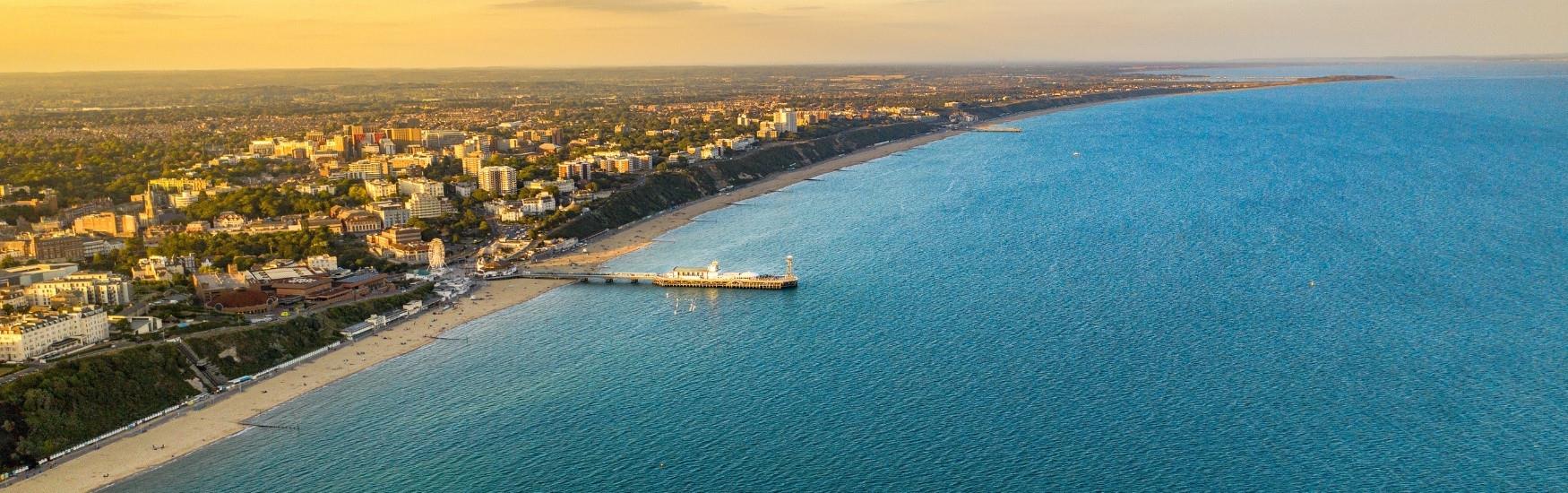 Aerial shot of the Bournemouth coast line with an orange sunset