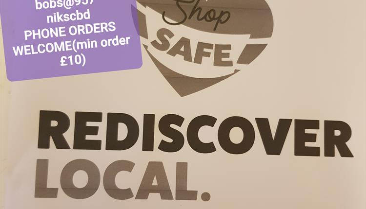Purple sticker with shop information over a brown poster with shop safe, rediscover local logo.