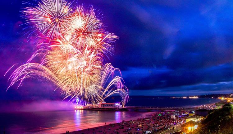 Beautiful colourful image of fireworks over Bournemouth Pier and the sea