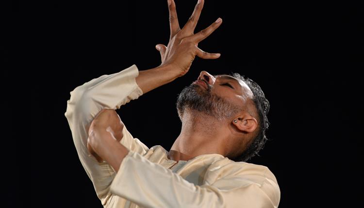 Indian male dancer with hands over face