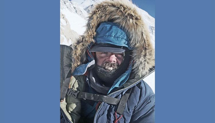 Man with a large winter jacket on a snowy mountain