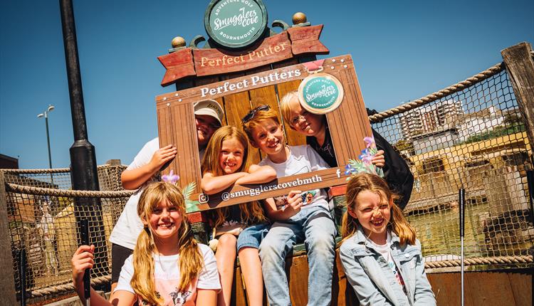 Group of children posing on winners throne after their round of mini golf