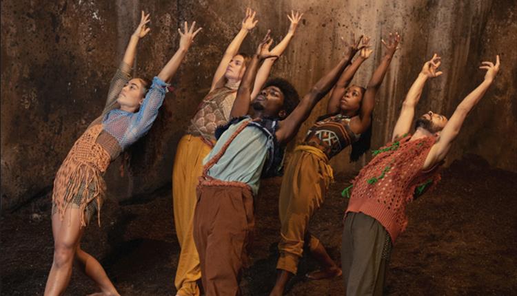 5 dancers stretching backwards against a brown backdrop