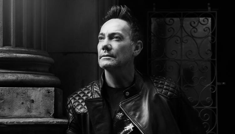Craig Revel Horwood in black and white looking up
