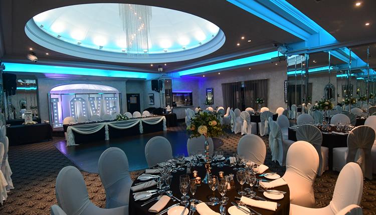 Large art deco room with white wedding decorations and stage