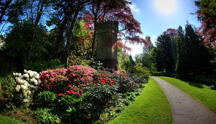 Folly tower surrounded by flora in the gardens 
