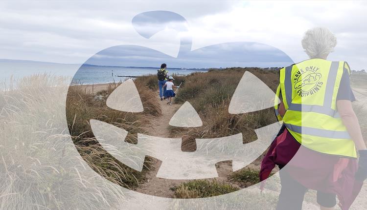 Two people and child picking up litter along the coast