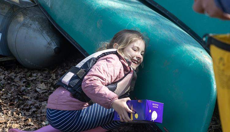 A young girl searching for Easter eggs during New Forest Activities Canoe Easter Egg Hunt