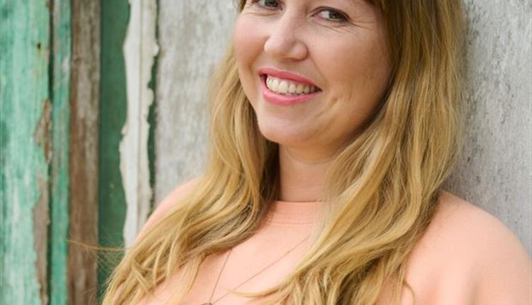 Lady smiling to camera in peach colour top