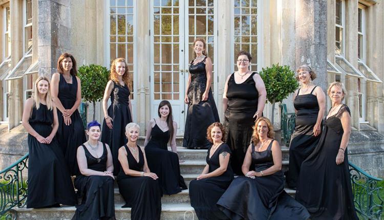 Goup of woman called La nova singers pose in front of highcliffe castle