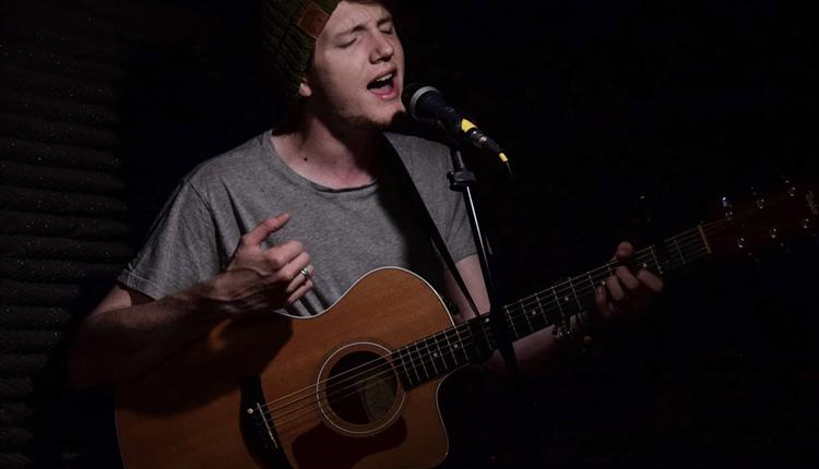 Man playing his guitar and singing