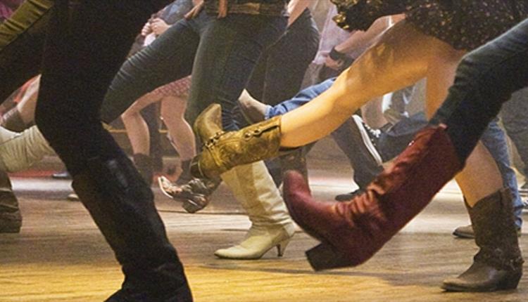 A group of people line dancing.