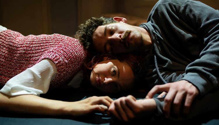 A photo of Sunnyside by Northern Rascals. A close up shot of two people, a man and a woman, lying down. The woman has her head on the floor and the ma