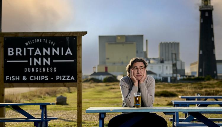 Micky Flanagan sat on a bench