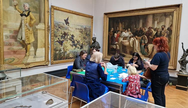 Families doing crafts in an art gallery