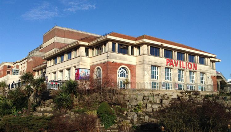 Large art deco building with blue sky and the word Pavilion on it