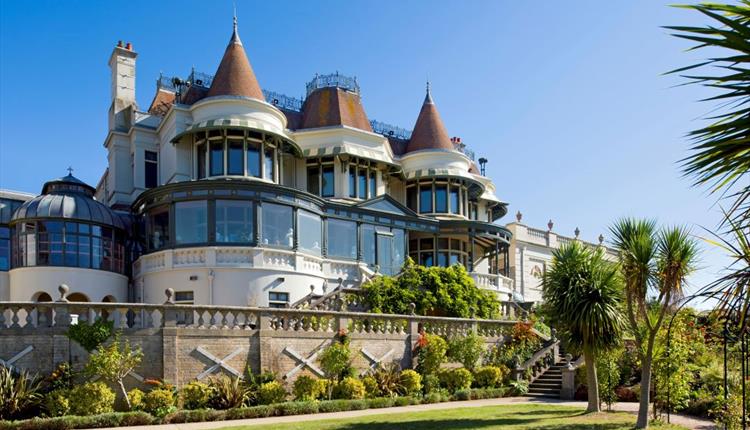 Victorian Villa with blue sky in the background and green lawn in the foreground