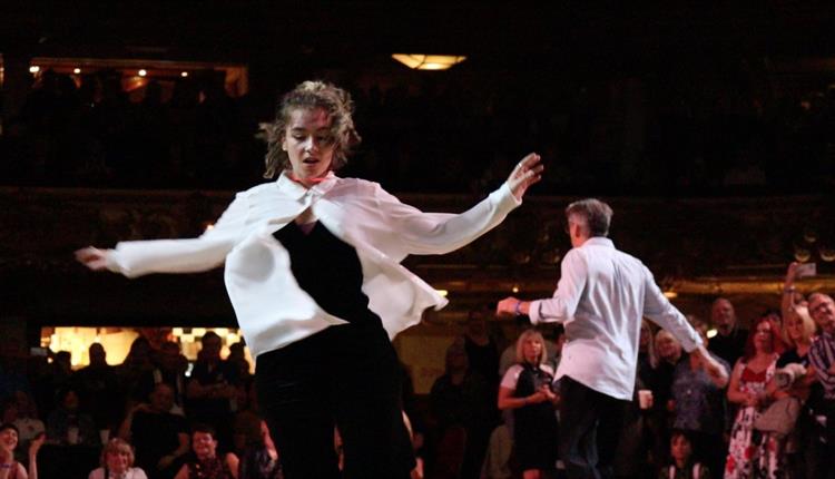 A photo of Sally Molloy for the Ocean Soul Social. She is in a white, long sleeved, flowy shirt that is only buttoned at the top. Underneath she is we