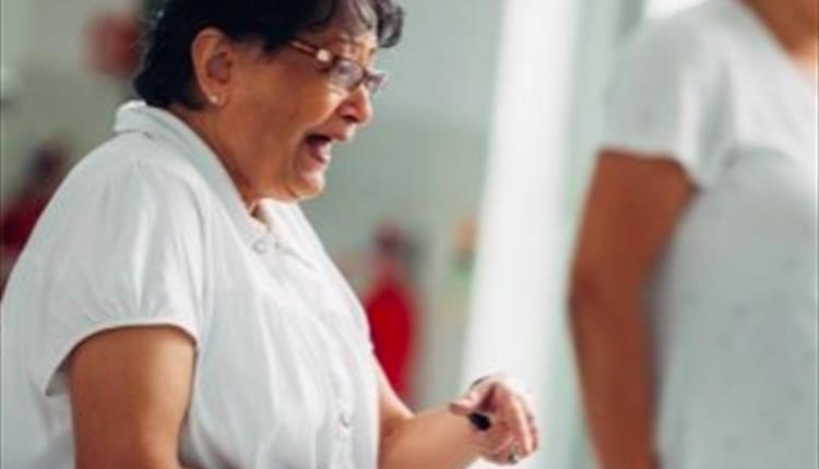 Lady in white clothing doing a dance move
