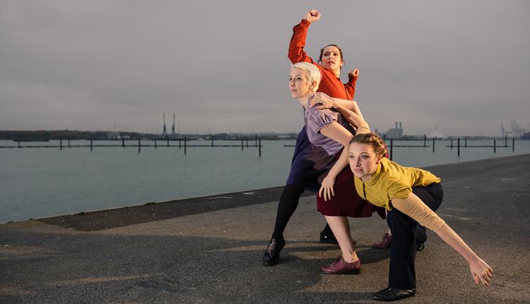 Image by Owen Benson of three women standing in a dance pose by the sea