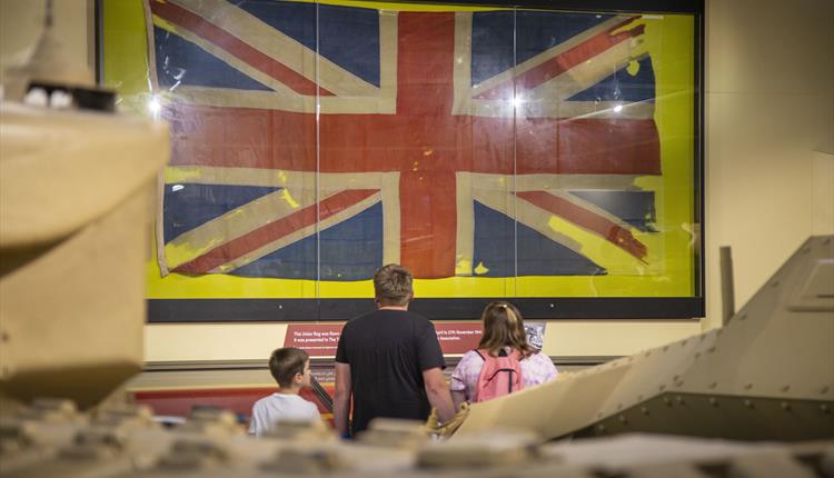 Visitors looking at old union jack flag on the wall