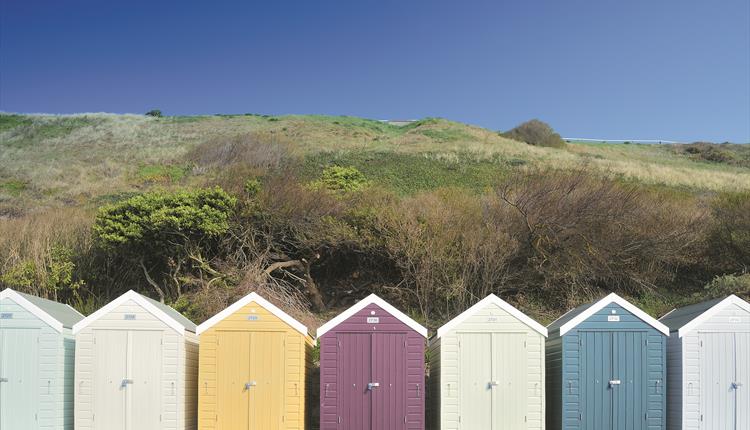 Colourful array of beach huts under the overcliff