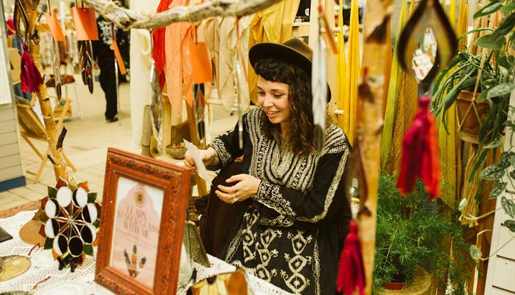 a lady in a shop looking at products with a smile on her face