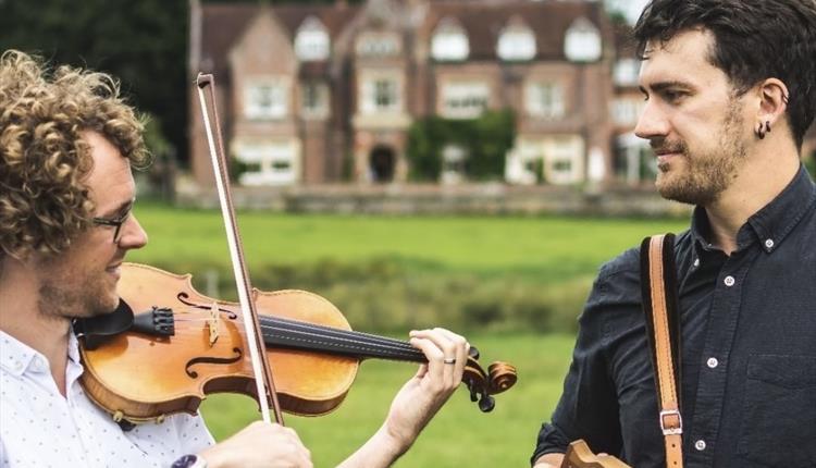 A duo called Bow & Box. Two men pictured, one playing the violin and the other the accordion.