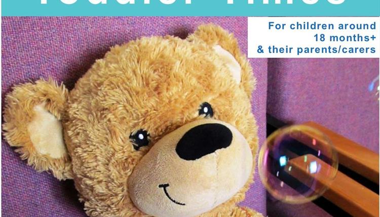 A Toddler Times poster with a brown bear on a purple background with a bubble near his face.