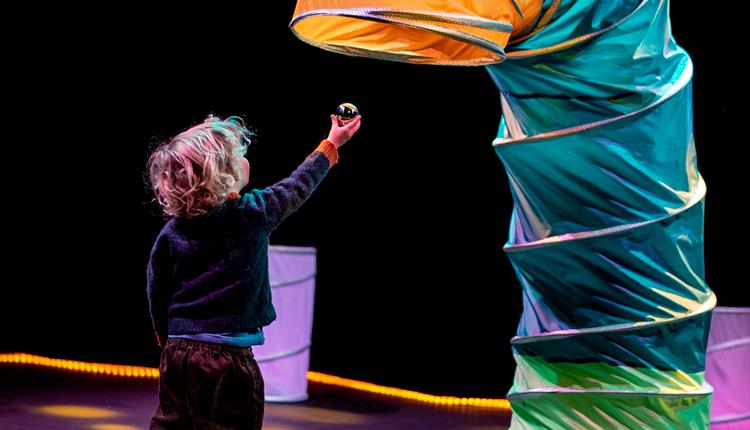 Small child playing with colourful tube