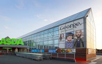 Exterior of the ASDA superstore with George clothing poster in glass atrium.