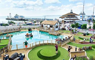 Visitors enjoying an 18 hole adventure golf course overlooking Bournemouth Pier
