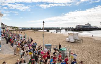 Bournemouth pier on a sunny day with crowds running along the promenade