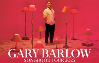 Image of lovely Gary standing proud among a series of lamps in a promotional photo for his 2025 tour