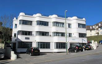 Exterior shot of the white Iona Holiday flats building from the road