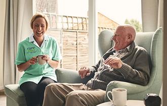 Nurse with older gentleman drinking tea