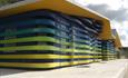 Exterior shot of green, blue and yellow coloured accessible huts