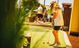 Girl playing adventure golf with sun hat