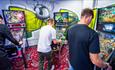 Three men playing pinball