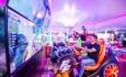 Two men playing a driving game in an arcade