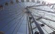 Looking up at the big wheel with the sun shining behind